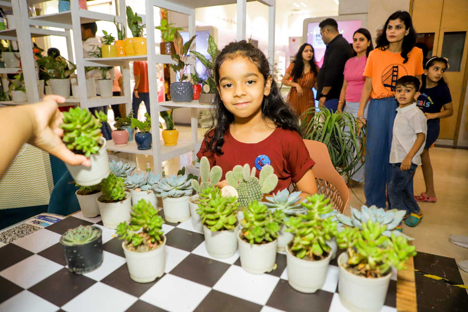 Girl with small plants pots in front of her